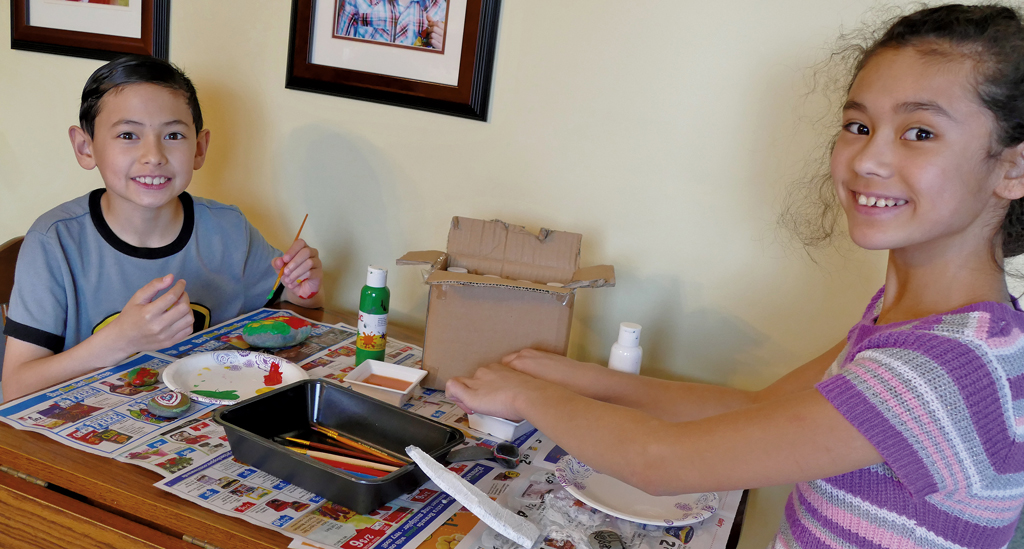 Ethan and Sophia painting rocks at their home in St. Albans